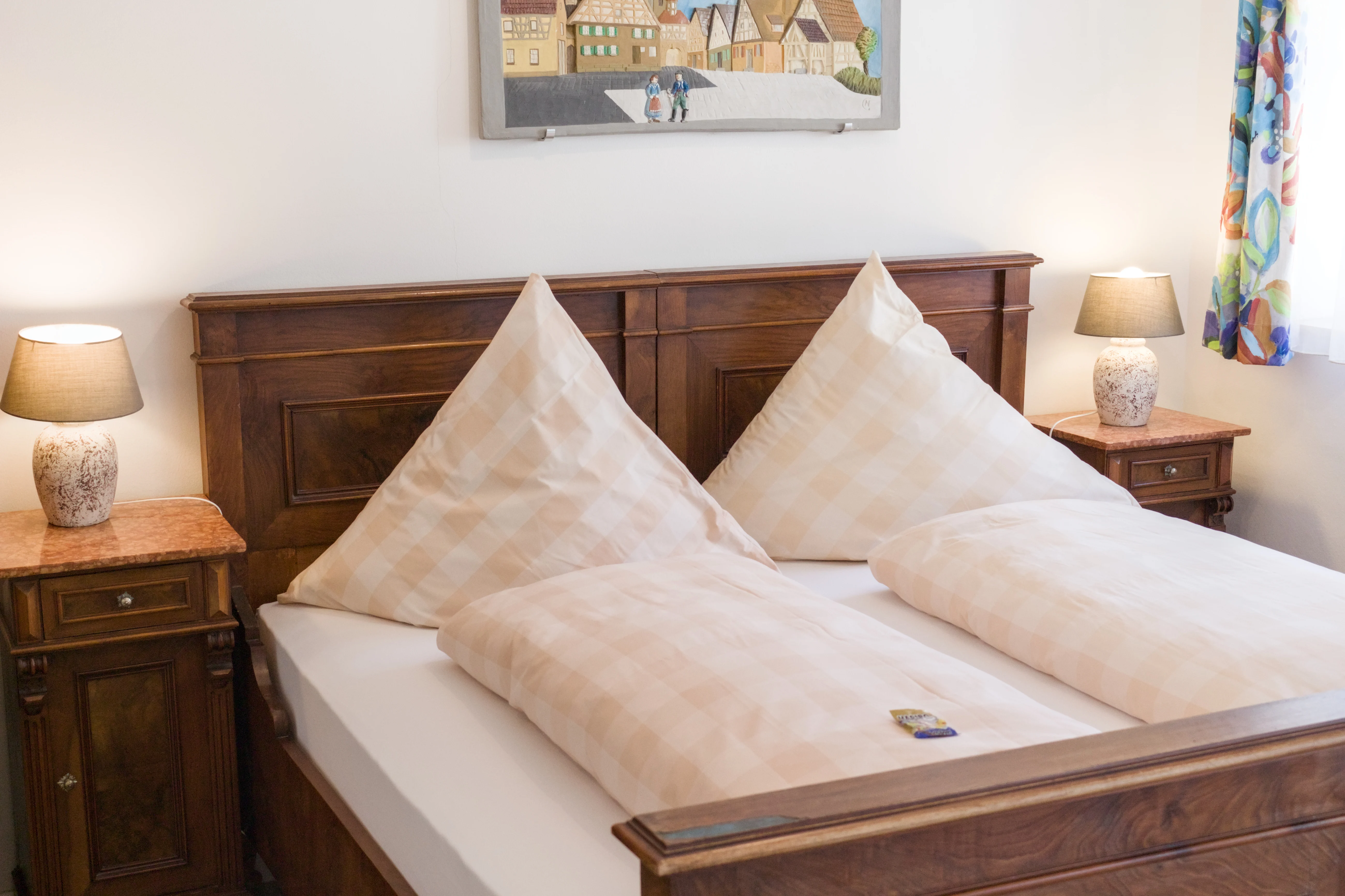 Doppelbett aus dunklem Holz mit Nachttischen