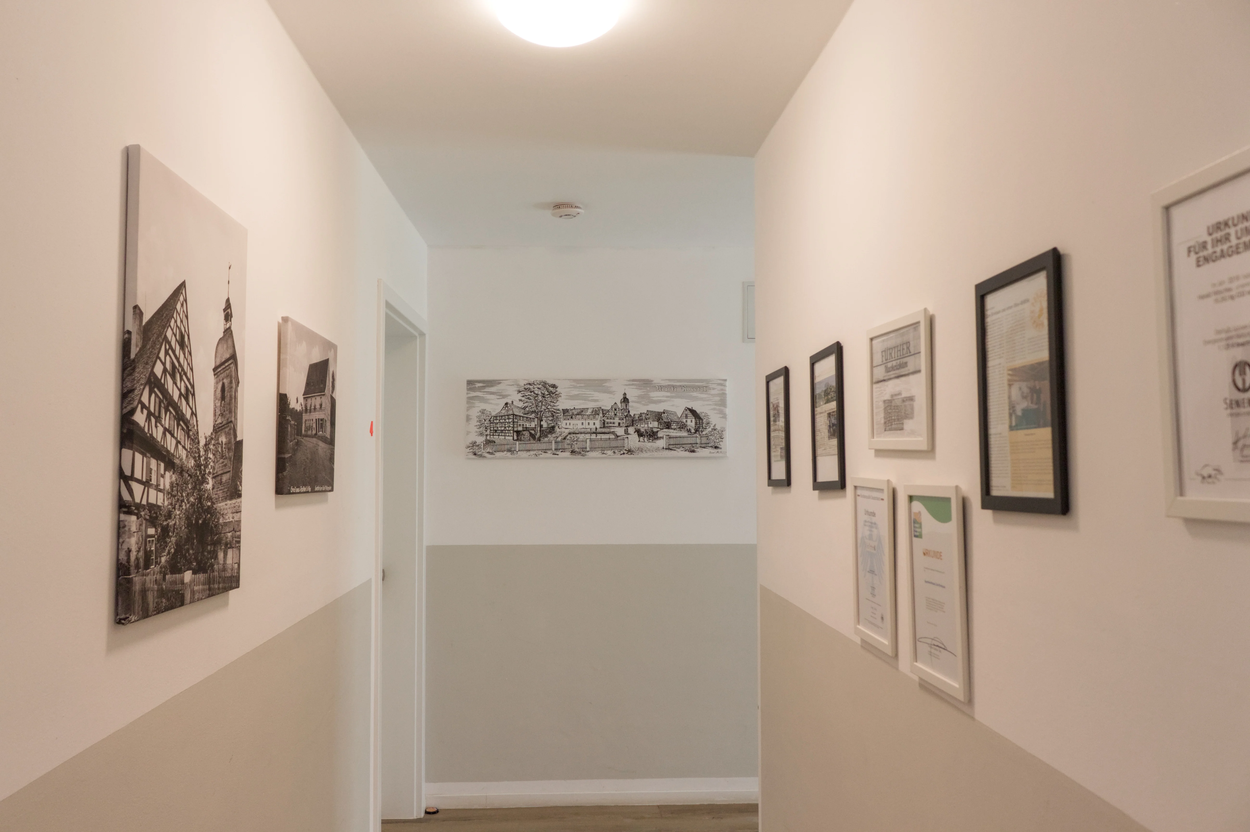 Heller Hausflur mit historischen Ansichten von Roßtal
