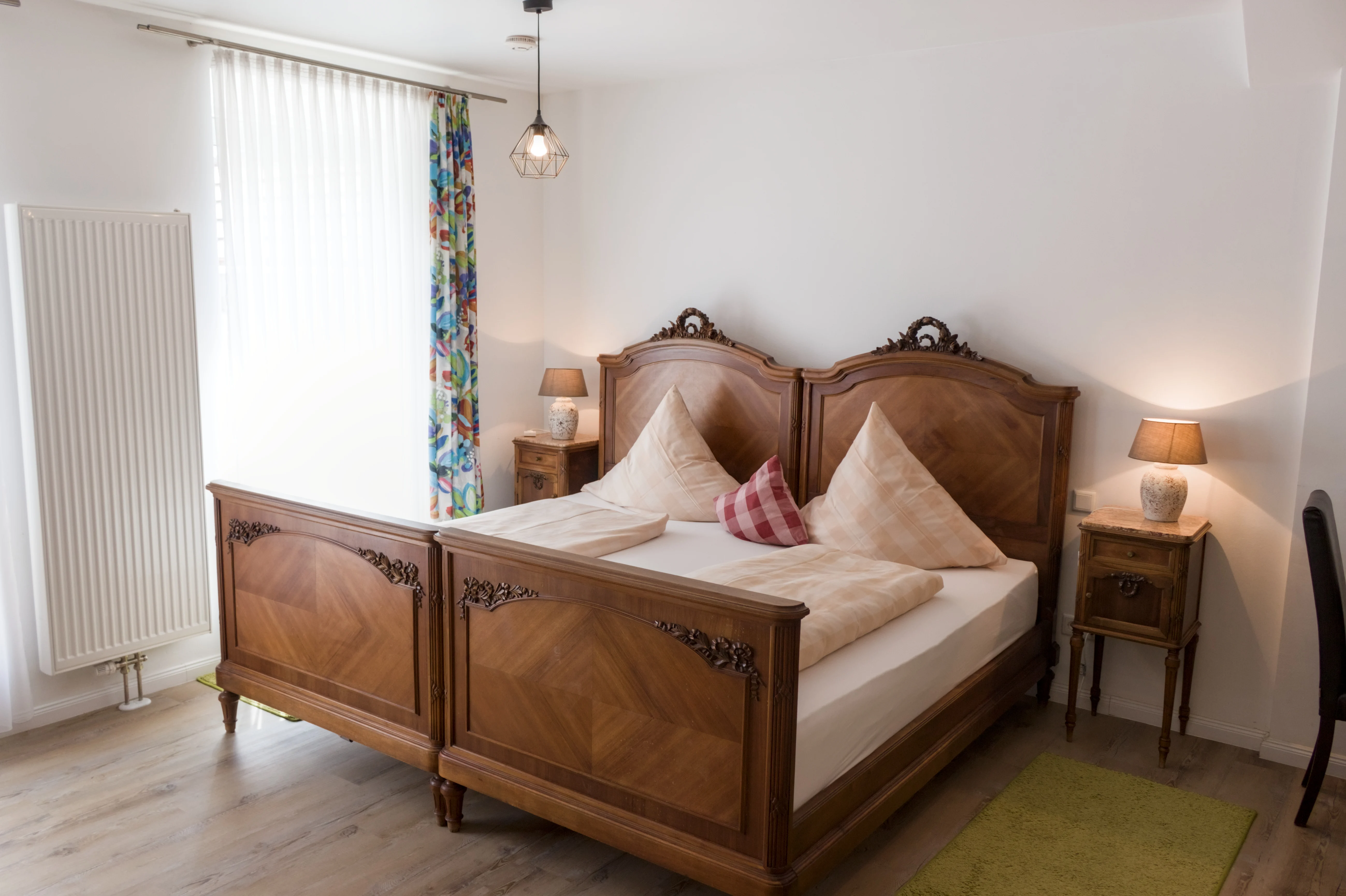 Doppelbett aus Holz im hellen Schlafbereich