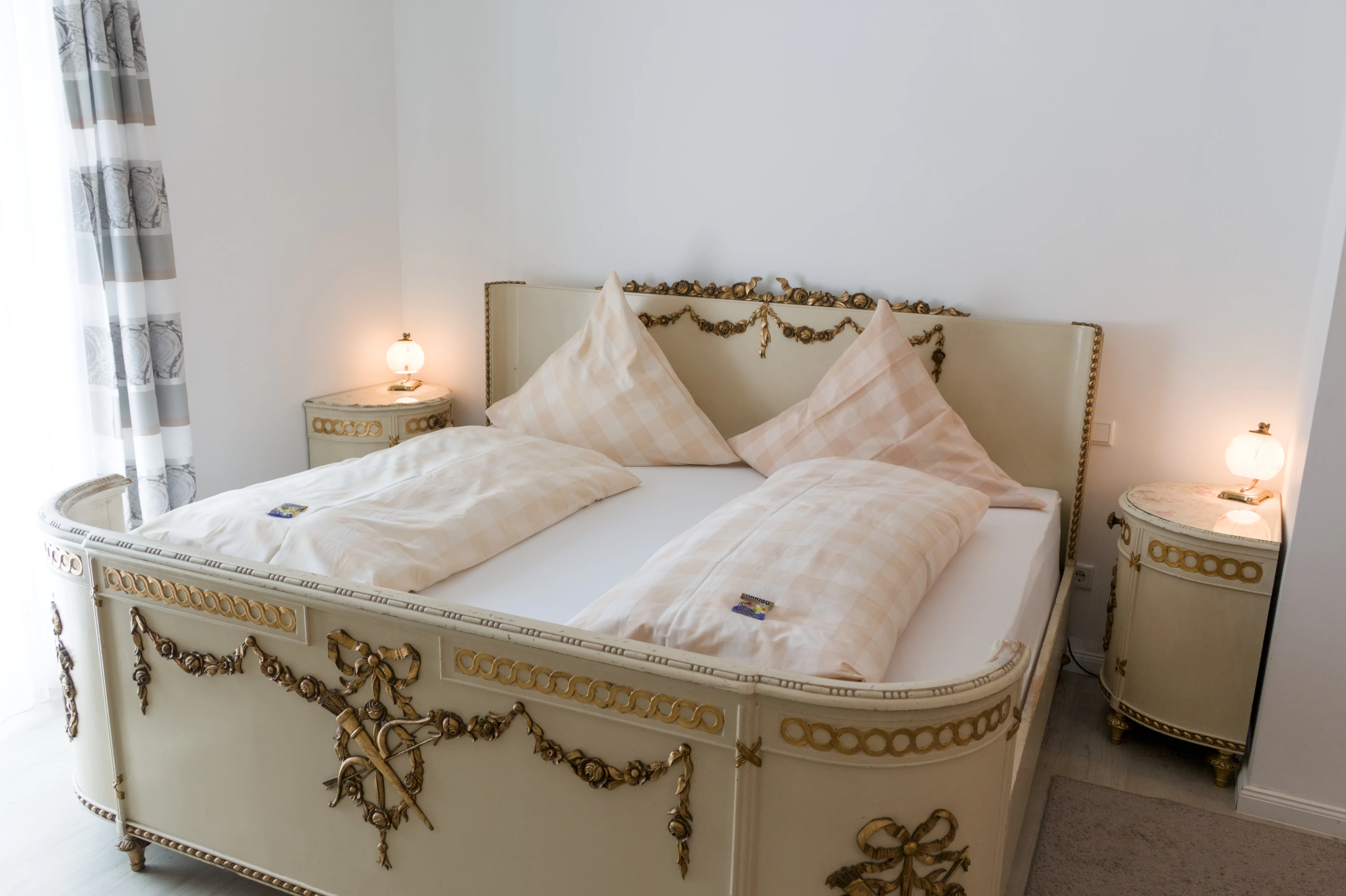 Doppelbett mit cremefarbenem, goldverziertem Holzrahmen